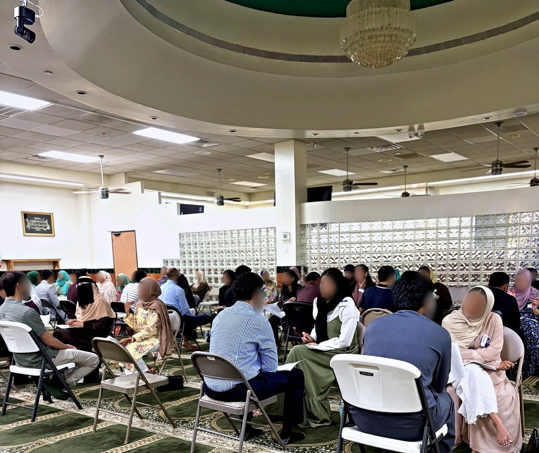 The hall at Masjid At-Taqwa under the chandelier, families seated in a wide circle for the introductions.